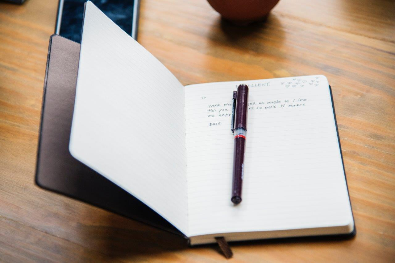 Handwritten notebook and pen